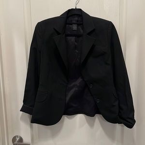 Cropped black blazer with rolled sleeves.